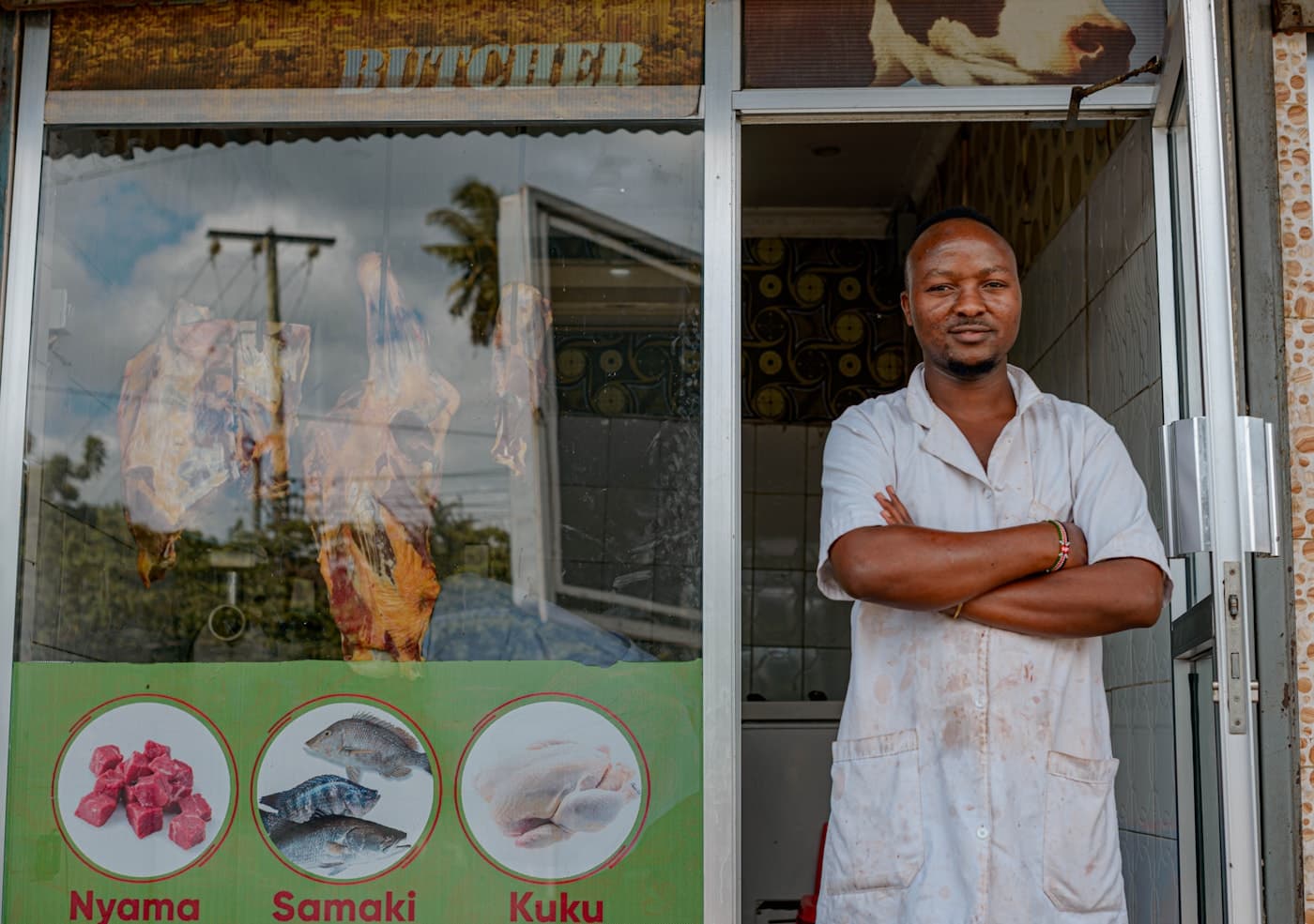 A small business owner standing in the doorway of his butcher shop in Dar es Salaam